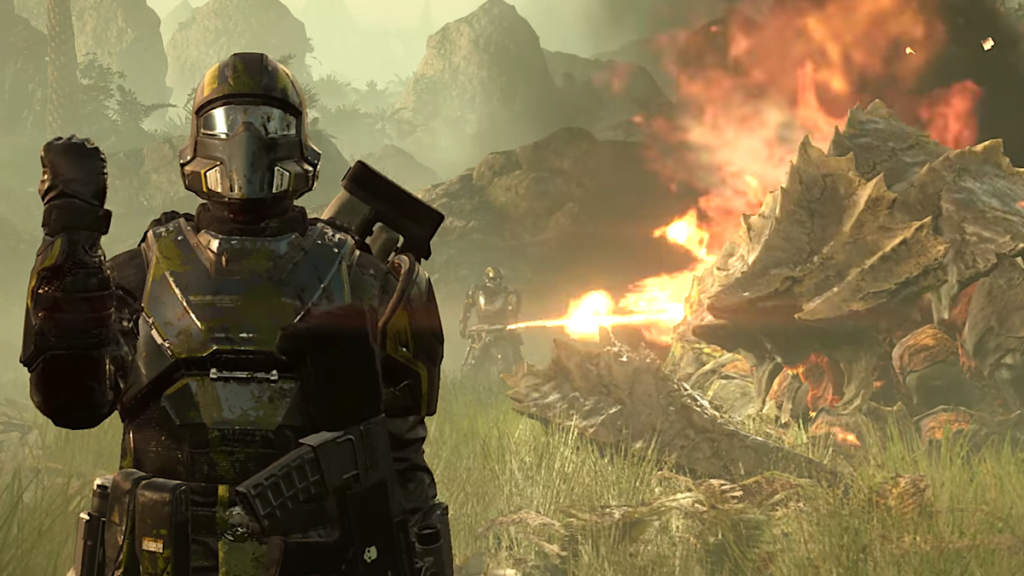 A soldier from Helldivers gives a patriotic salute while their comrade burns an alien corpse to death in the background.