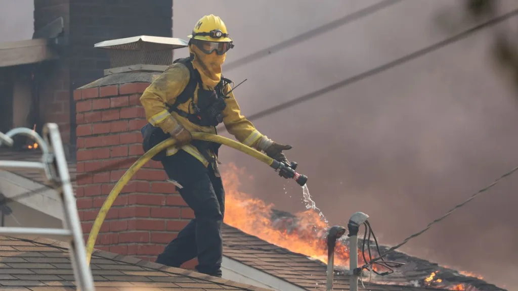 Mentre gli incendi di Los Angeles infuriavano, Riot Games ha fornito un generatore a una caserma dei pompieri rimasta senza corrente 10 A cropped Cal Fire photo of a firefighter on a rooftop during the 2025 Palisades Fire.