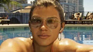 GTA 6 voice actors and cast: Lucia reclines by a pool in Vice City, her hair pulled back and her eyes obscured by fashionable sunglasses.