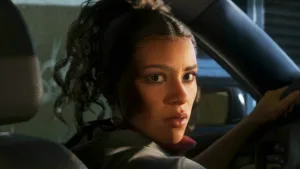 Lucia, protagonista di Grand Theft Auto VI, al volante di un'automobile mentre si gira indietro