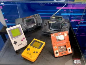 Console portatili degli anni ottanta e novanta appoggiate una accanto all'altra, fra cui Game Boy, Game & Watch, Atari Lynx e Game Gear
